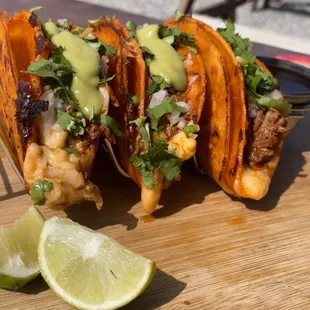 a hand drizzling sauce onto a taco