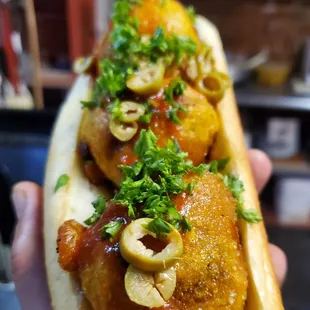 a hand holding a hot dog
