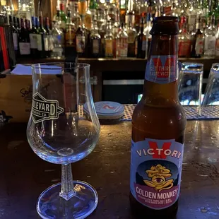 a beer and a glass on a bar