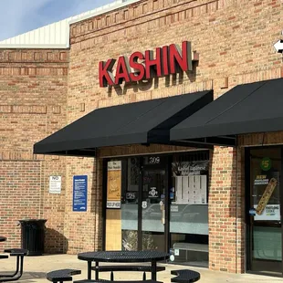 the outside of a restaurant with tables and umbrellas