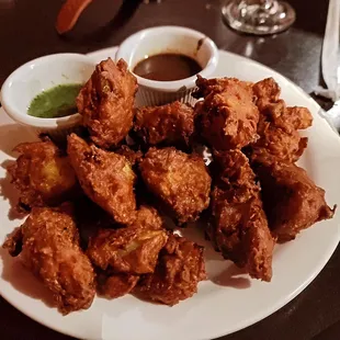 Vegetable Pakoras appetizer shared plate with red and green chutney dipping my favorite