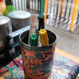 a bucket of pens and markers