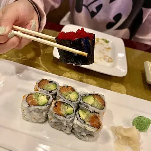 a person eating sushi with chopsticks