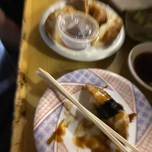 a plate of sushi and chopsticks on a table