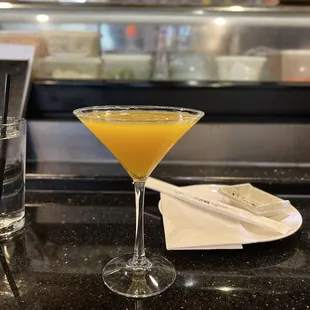 a glass of orange juice on a counter