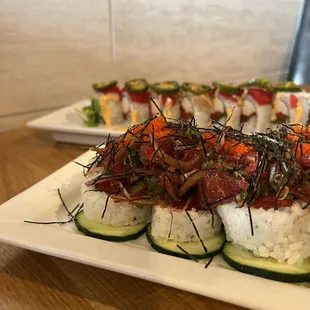 a plate of sushi and cucumbers