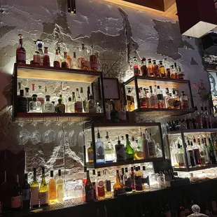 a wall of liquor bottles in a bar