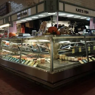 a woman standing in front of a deli counter