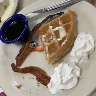 Half eaten kids waffle with bacon