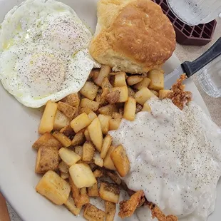 Chicken fried chicken, eggs, biscuit, and potatoes