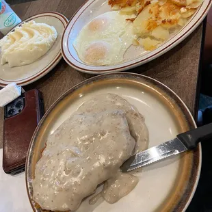 Country fried steak breakfast with a side of mashed potatoes