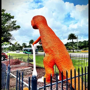 an orange dinosaur statue