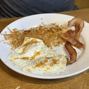 2 egg breakfast with bacon and hash browns.