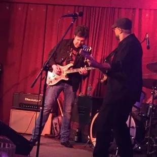 two men playing guitar