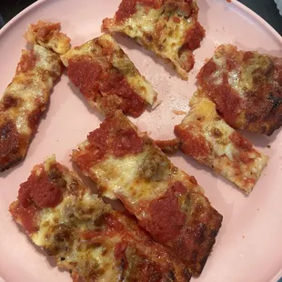 four slices of pizza on a pink plate