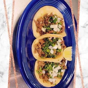 three tacos on a blue plate