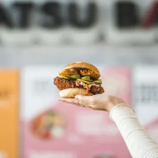 a hand holding a sandwich