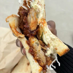 a person holding a sandwich