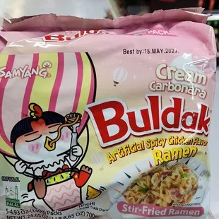 a hand holding a bag of buldak