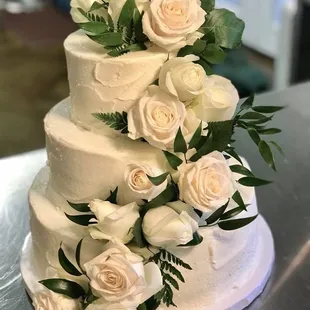 a wedding cake with white roses