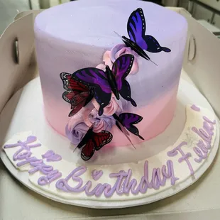 a birthday cake decorated with butterflies