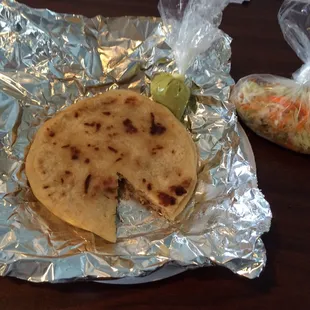 Two HOT pupusas w/spicy green sauce &amp; curtido. Simply wrapped in foil on a paper plate, no knife &amp; fork. Only $1.50/ ea.