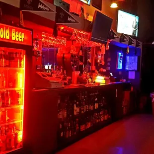 a dimly lit bar with neon lights