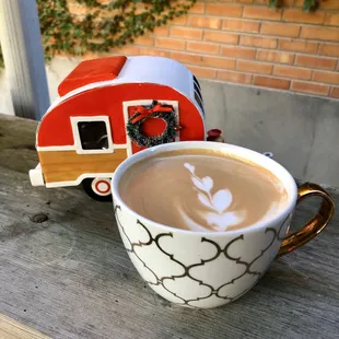 a cup of coffee and a toy caravan