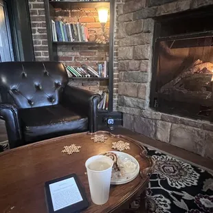 a coffee cup on a table in front of a fireplace