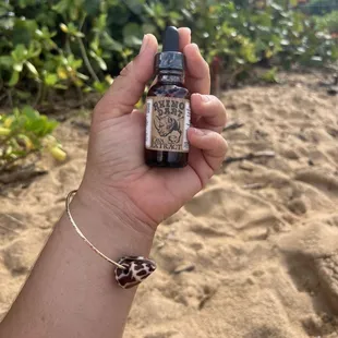 a hand holding a bottle of kava