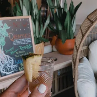 a person holding a pineapple drink