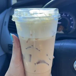 a hand holding a cup of iced coffee