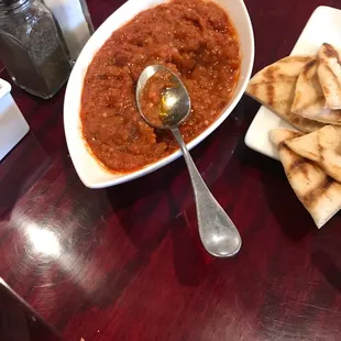 a bowl of chili and pita chips