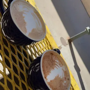 two cups of coffee on a yellow table