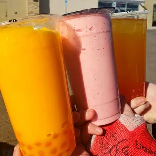 Mango milk tea with peach poppers, strawberry smoothie, mango tea with strawberry poppers