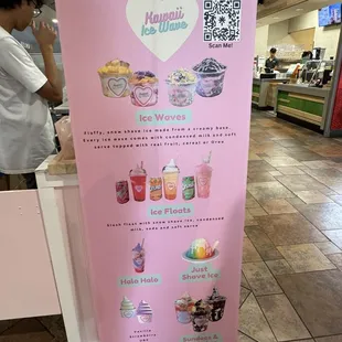 a woman standing in front of a pink sign