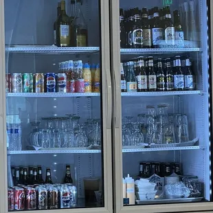 Assortment of beverage and beer in refrigerator with glass mugs chilled inside as well! Nice touch for a cold mug with your beer!