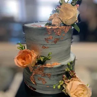 a three tiered cake with flowers on top