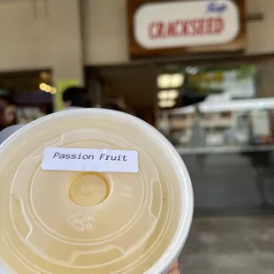 a person holding a cup of passion fruit