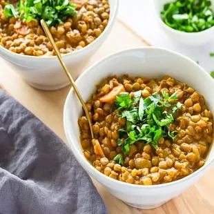 two bowls of lentils on a cutting board