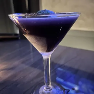 a purple cocktail in a martini glass