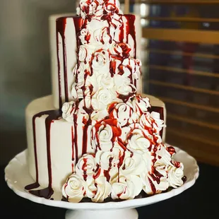 a three tiered cake with white and red icing