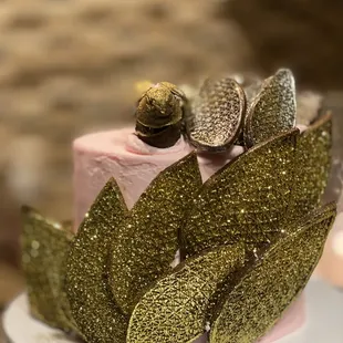 a cake decorated with gold leaves