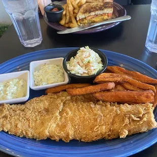 A huge portion of haddock with sweet potato fries and slaw.
