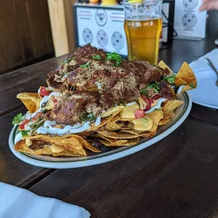 a plate of nachos and a glass of beer