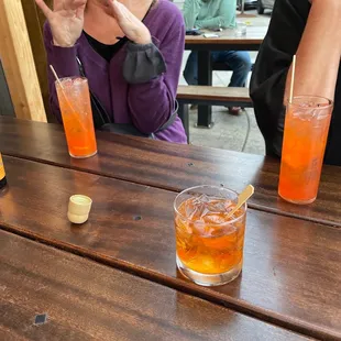 two people sitting at a table with drinks