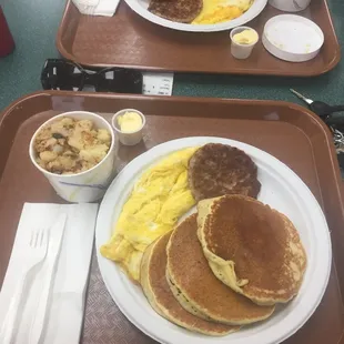 Pancakes, two eggs, and sausage with a side of home fries and butter