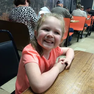 a little girl sitting at a table