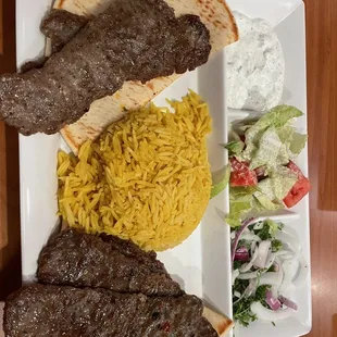 Gyro plate with tzatziki sauce (yummy), salad and rice.