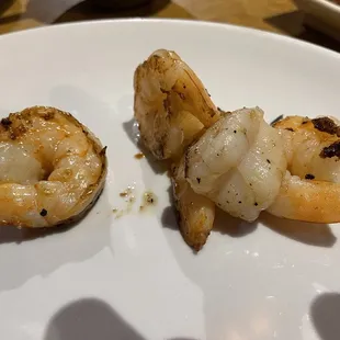 two pieces of shrimp on a white plate